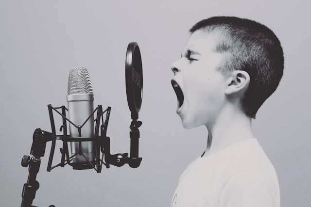 boy screaming into microphone by Jason Rosewell 