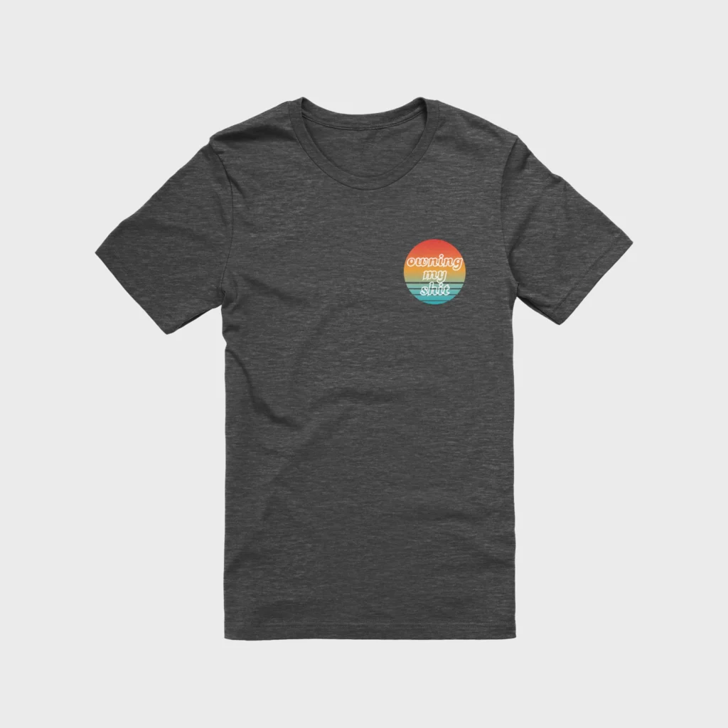 Owning My Shit black t-shirt with small pocket-sized multicolored graphic